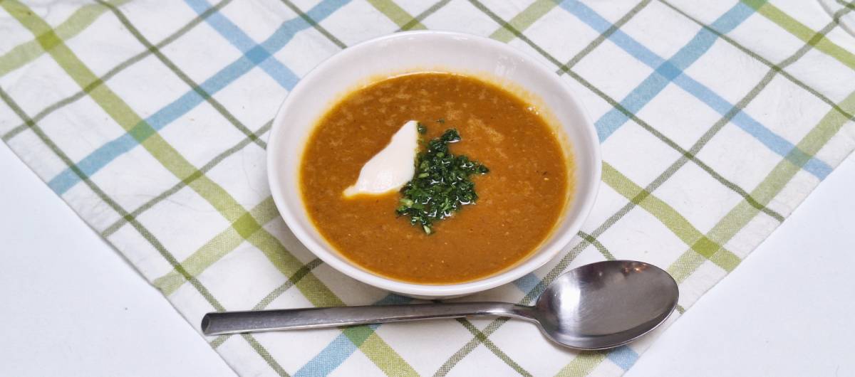 Picture of a lentil vegetable soup with soy yoghurt and parsley