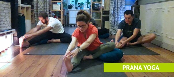 Drie yogabeoefenaars in een zittende yogahouding